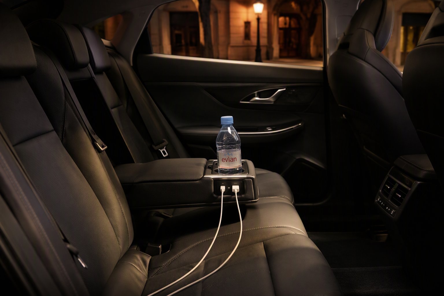 Banquette arrière de la Toyota Prius : bouteille d'eau offerte et câbles de charge USB à disposition